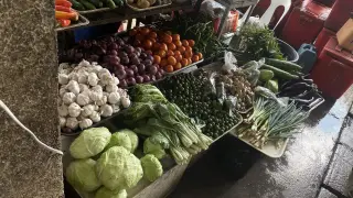 Ilustrasi: Berbagai jenis sayuran dan bumbu dapur tertata di lapak pasar tradisional.