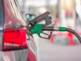 Ilustrasi: Nozel pompa bensin hijau terpasang pada lubang tangki bahan bakar mobil.