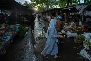 Ilustrasi: Suasana pagi di pasar tradisional dengan pedagang dan warga berjalan di jalan becek.