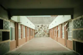 Ilustrasi: Lorong terbuka di antara dua deretan bangunan yang sepi dan bersih.