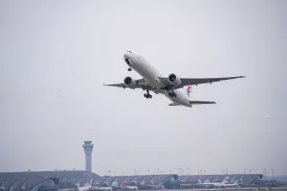 Ilustrasi: Pesawat komersial lepas landas di atas bandara dengan menara pengawas dan terminal modern.