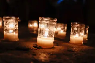 Ilustrasi: Lilin-lilin menyala di dalam toples kaca di atas lantai dalam suasana temaram.