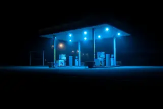 Ilustrasi: Stasiun pengisian bahan bakar sepi di malam hari dengan pencahayaan lampu biru berkabut.