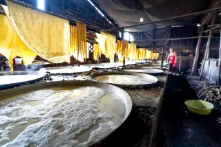 Ilustrasi: Proses pembuatan kembang tahu tradisional di wadah besar di dalam bengkel produksi.