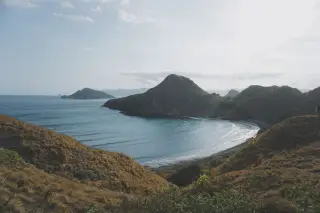 Ilustrasi: Pemandangan teluk berpasir dengan perbukitan savana di Pulau Padar, Nusa Tenggara Timur.