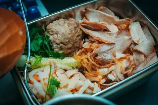 Ilustrasi: Kotak makan logam berisi olahan daging, bakso, dan sayuran.