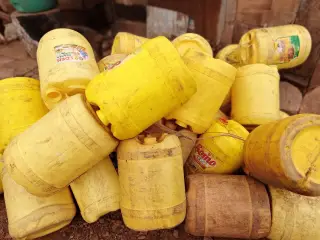 Ilustrasi: Tumpukan jeriken plastik warna kuning bekas pakai di luar ruangan.