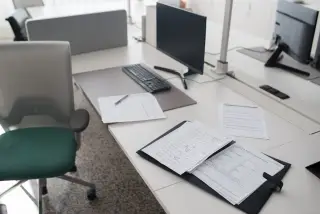 Ilustrasi: Meja kerja kantor modern dengan komputer, kursi, berkas, dan dokumen formulir.